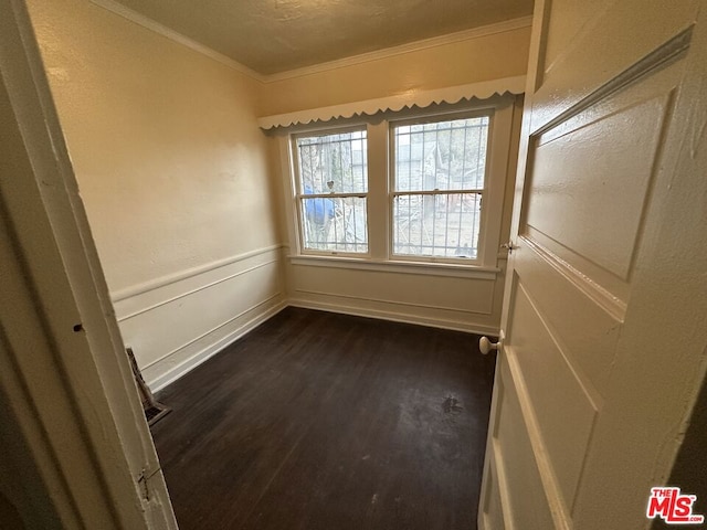 unfurnished room with dark hardwood / wood-style flooring and crown molding