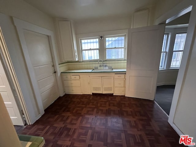 kitchen featuring dark parquet flooring, tasteful backsplash, and sink