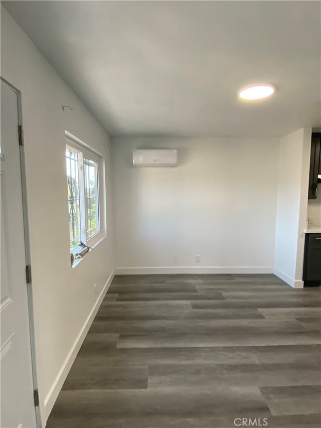 interior space with dark wood-type flooring and a wall unit AC