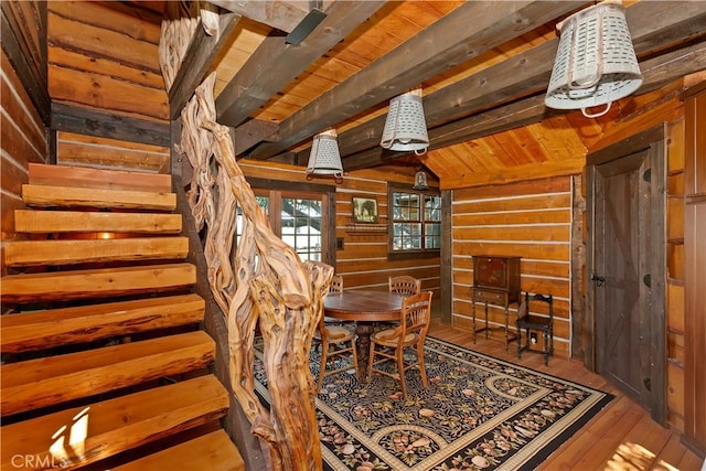 unfurnished dining area with wood ceiling, beam ceiling, wooden walls, and hardwood / wood-style floors