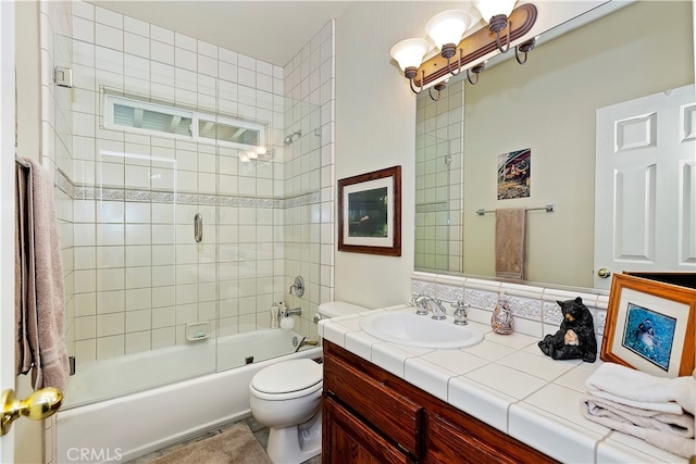 full bathroom featuring vanity, shower / bath combination with glass door, and toilet