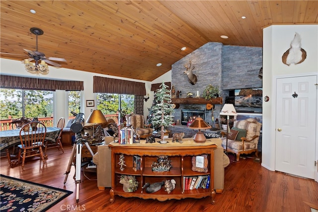 living room with ceiling fan, hardwood / wood-style flooring, wooden ceiling, and a stone fireplace