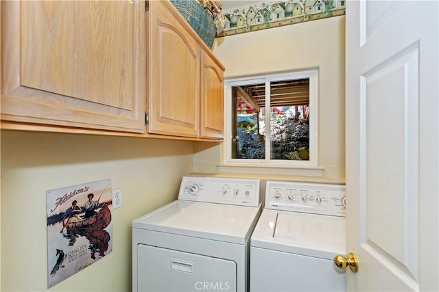 washroom with washer and dryer and cabinets