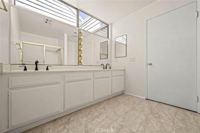 bathroom featuring a skylight, vanity, and a shower with shower door