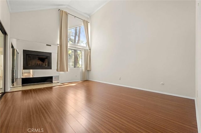 unfurnished living room featuring hardwood / wood-style flooring, ornamental molding, and high vaulted ceiling