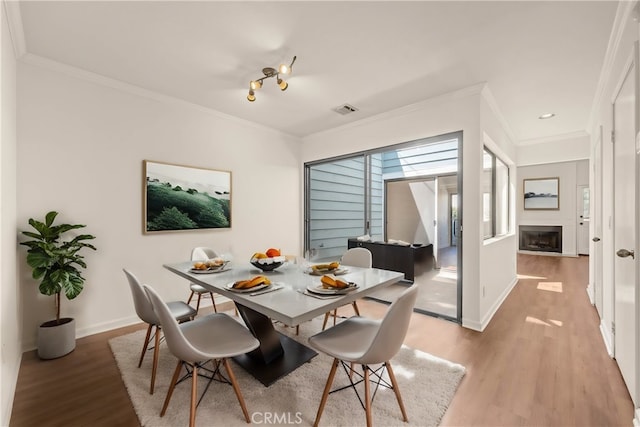 dining space featuring light hardwood / wood-style floors and ornamental molding