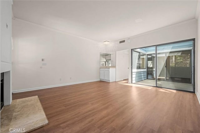 unfurnished living room with crown molding and wood-type flooring