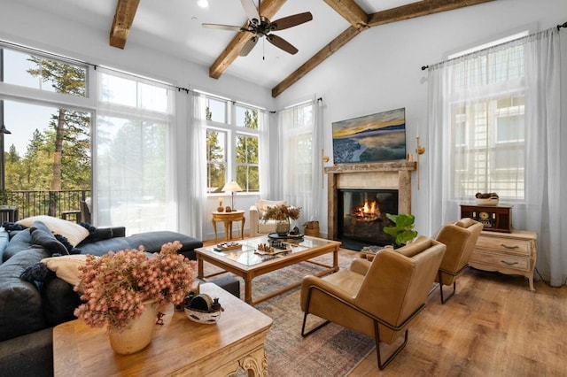 sunroom featuring ceiling fan, a fireplace, and lofted ceiling with beams