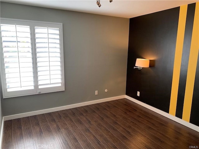 empty room featuring dark wood-type flooring and a healthy amount of sunlight