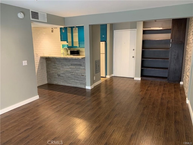 unfurnished living room with dark hardwood / wood-style flooring