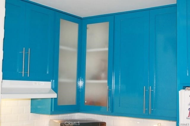 interior space with blue cabinetry and tasteful backsplash