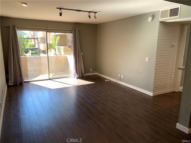 unfurnished room with rail lighting and dark hardwood / wood-style floors