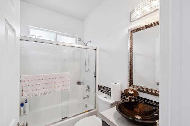 full bathroom featuring vanity, shower / bath combination with glass door, and toilet