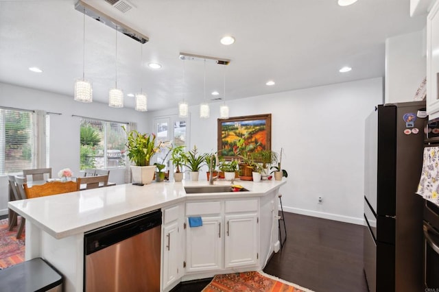 kitchen featuring stainless steel appliances, sink, decorative light fixtures, white cabinets, and dark hardwood / wood-style flooring