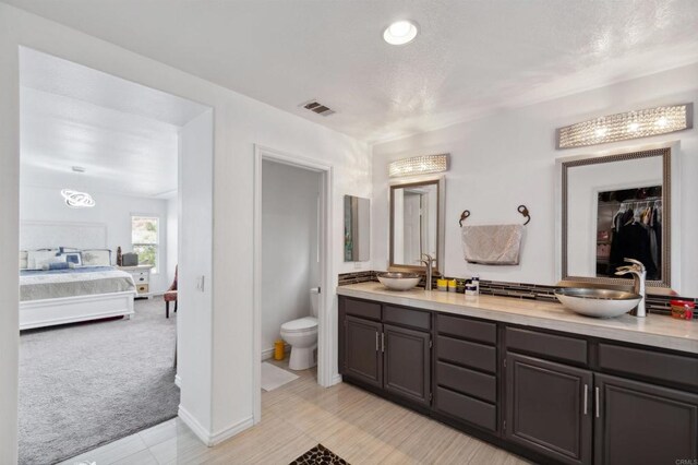 bathroom featuring toilet, vanity, and tile patterned flooring