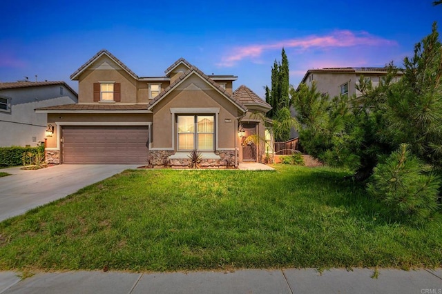 view of front of house featuring a garage and a lawn