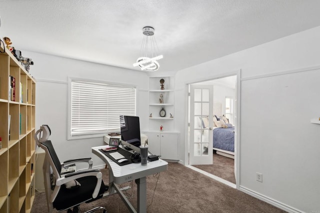 office with an inviting chandelier, a textured ceiling, and dark colored carpet