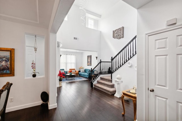 entrance foyer with dark wood-type flooring and a high ceiling