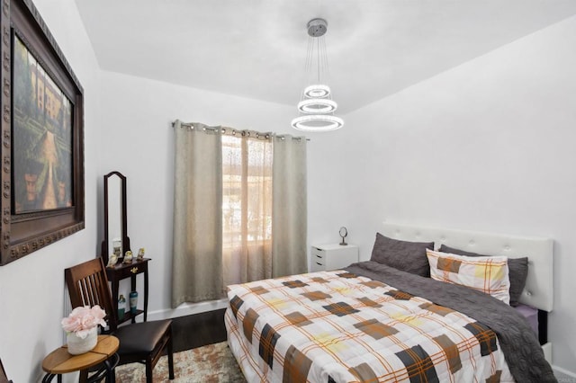 bedroom with an inviting chandelier and wood-type flooring