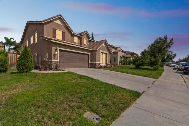 view of front of home with a garage and a lawn