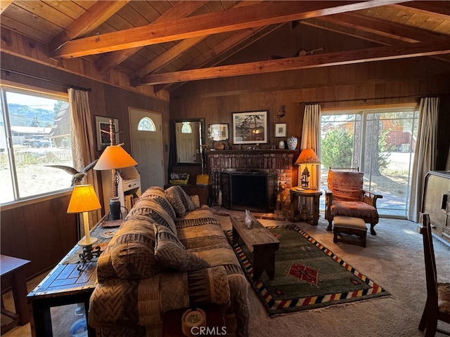 carpeted living room with a fireplace, a healthy amount of sunlight, and vaulted ceiling with beams