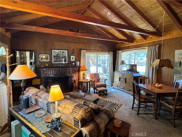 carpeted living room featuring vaulted ceiling with beams, a fireplace, wooden ceiling, and wooden walls