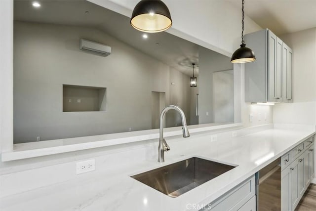 kitchen with a wall mounted AC, decorative light fixtures, lofted ceiling, light stone counters, and sink