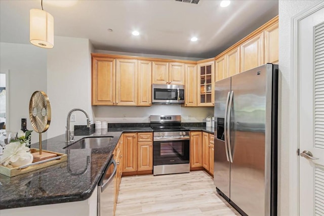 kitchen with sink, hanging light fixtures, kitchen peninsula, and appliances with stainless steel finishes