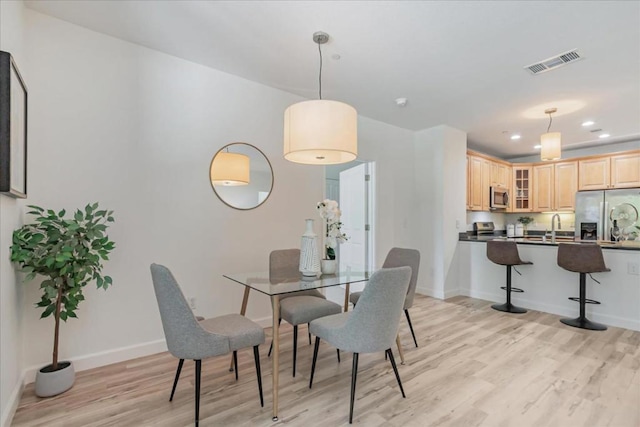 dining room with sink and light hardwood / wood-style flooring