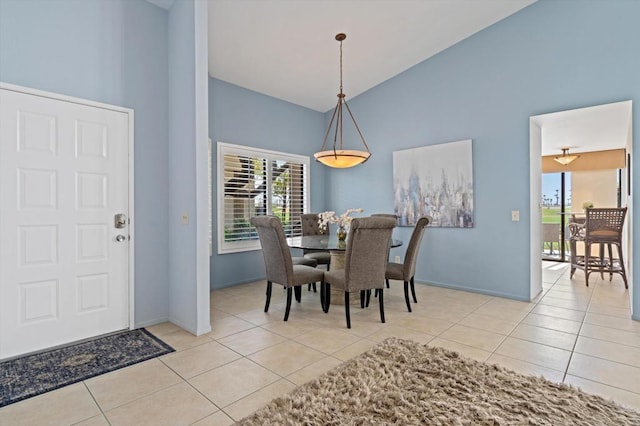 tiled dining area featuring high vaulted ceiling