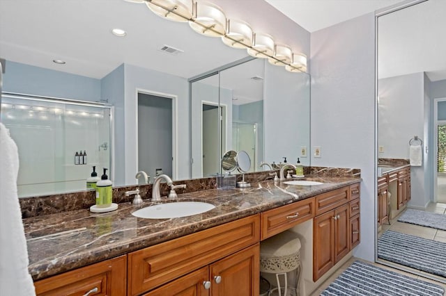 bathroom featuring tile patterned floors, walk in shower, and vanity