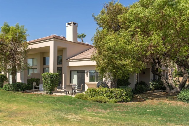 rear view of house featuring a yard and a patio area