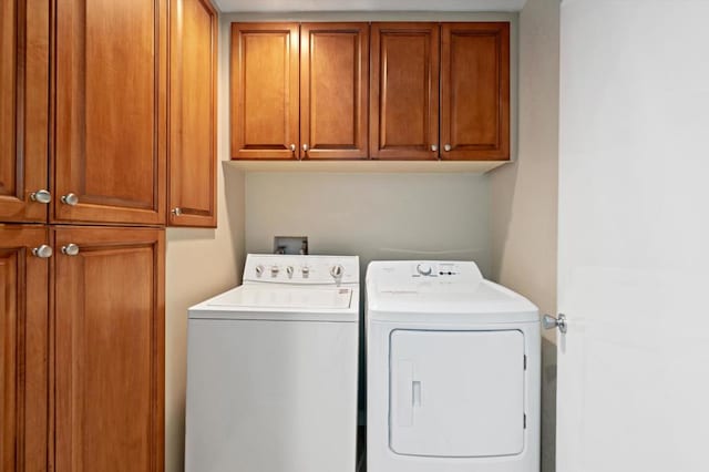 washroom with cabinets and washing machine and dryer