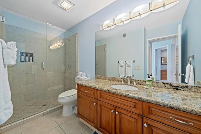 bathroom featuring tile patterned flooring, toilet, walk in shower, and vanity