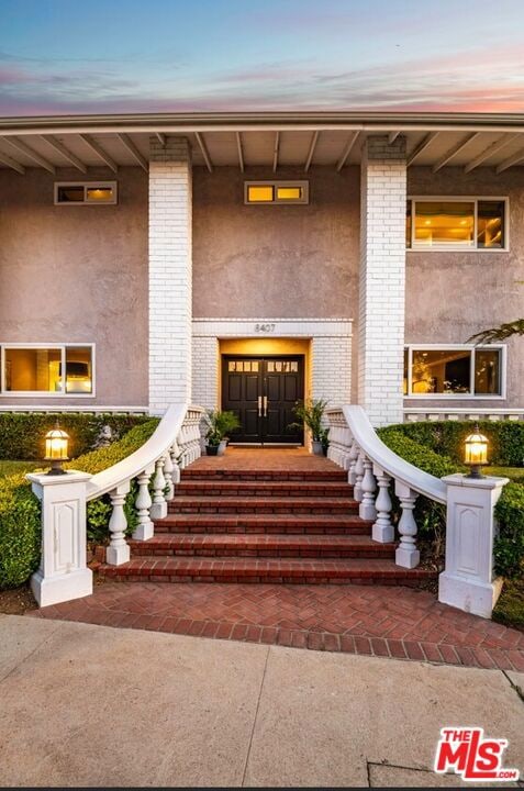 exterior entry at dusk with covered porch