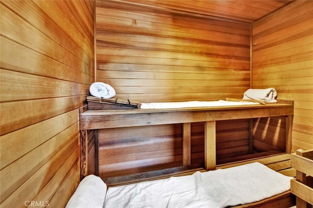 view of sauna / steam room with wooden ceiling and wooden walls