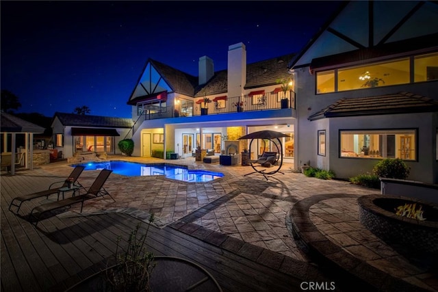 pool at twilight with a patio area