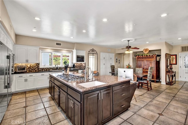 kitchen with dark brown cabinets, white cabinetry, sink, and ceiling fan