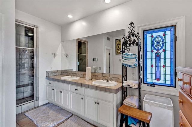 bathroom with walk in shower, vanity, and tile patterned flooring