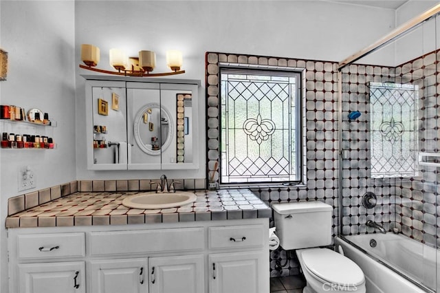 full bathroom featuring enclosed tub / shower combo, vanity, toilet, and tile patterned floors