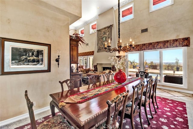 dining room with an inviting chandelier, a towering ceiling, and light tile patterned flooring