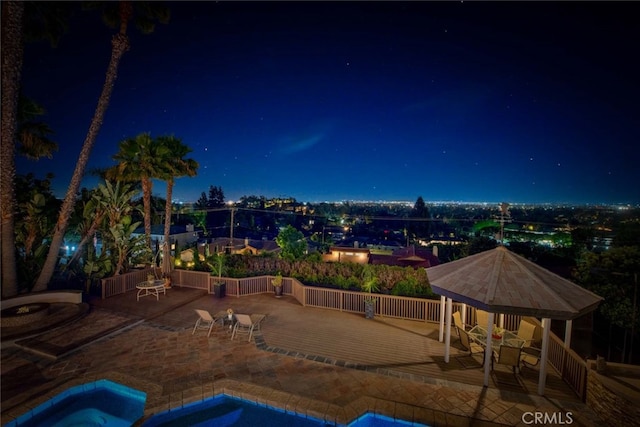 pool at twilight with a gazebo, a jacuzzi, and a patio