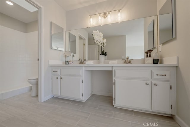 bathroom featuring dual vanity, tile patterned floors, and toilet