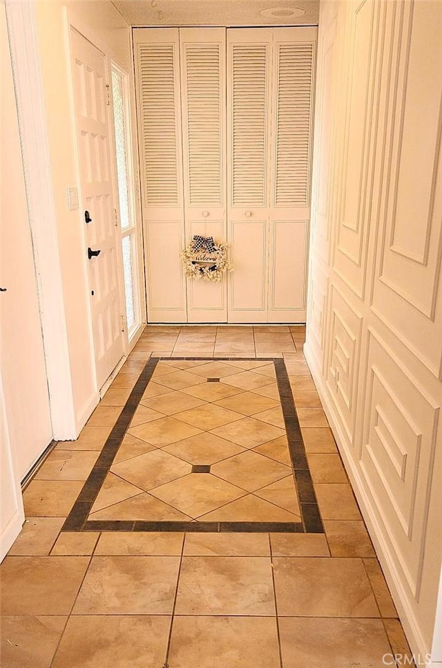 hall featuring light tile patterned floors