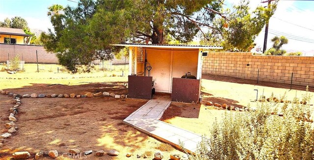 entry to storm shelter with fence and an outdoor structure