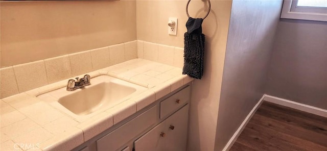 bathroom featuring vanity, baseboards, and wood finished floors