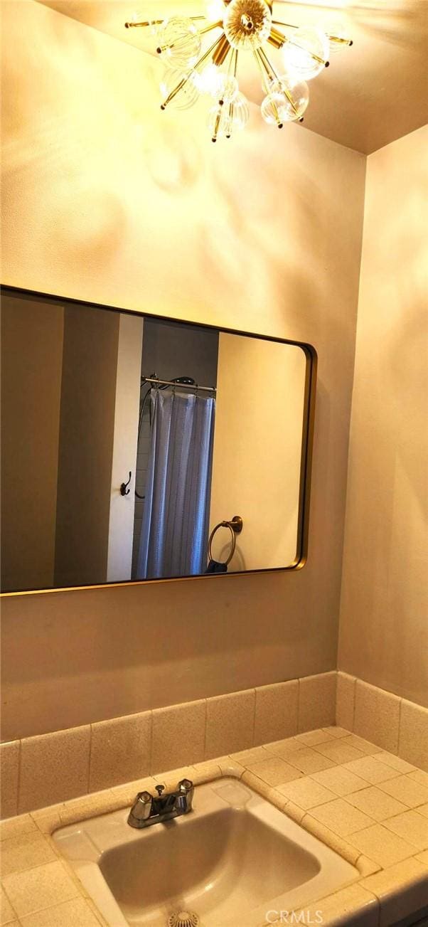 bathroom with a sink and a notable chandelier