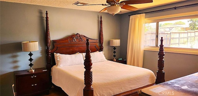 bedroom featuring ceiling fan, visible vents, and a textured ceiling