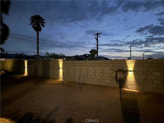 yard at dusk featuring a patio