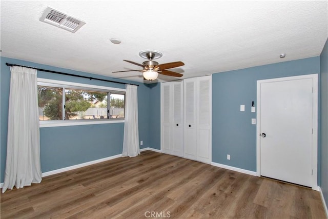57825 El Dorado Dr, Yucca Valley, CA 92284 - unfurnished bedroom featuring wood finished floors, a closet, a textured ceiling, and ceiling fan